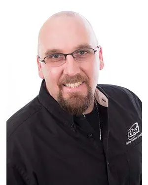 A bald man with glasses and beard wearing a black shirt.