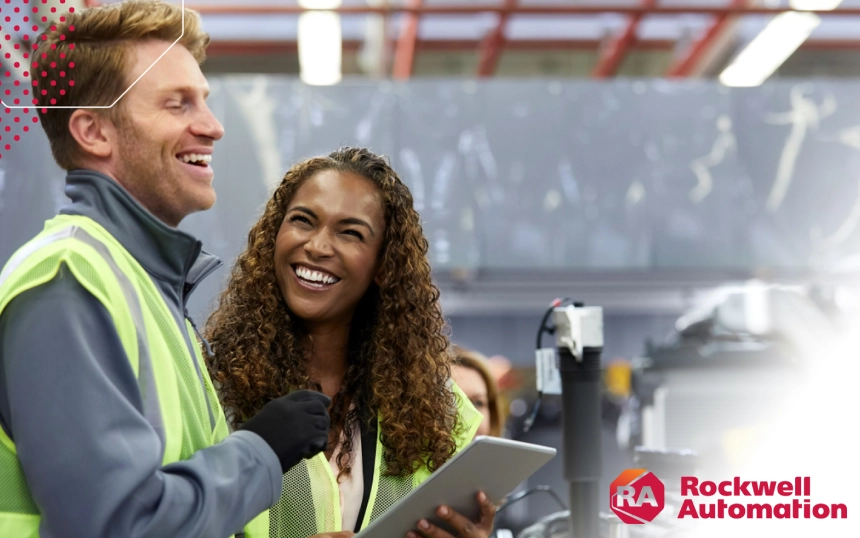 Two people are smiling while holding a tablet.