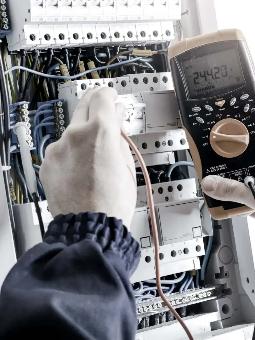 A person is working on an electrical panel.