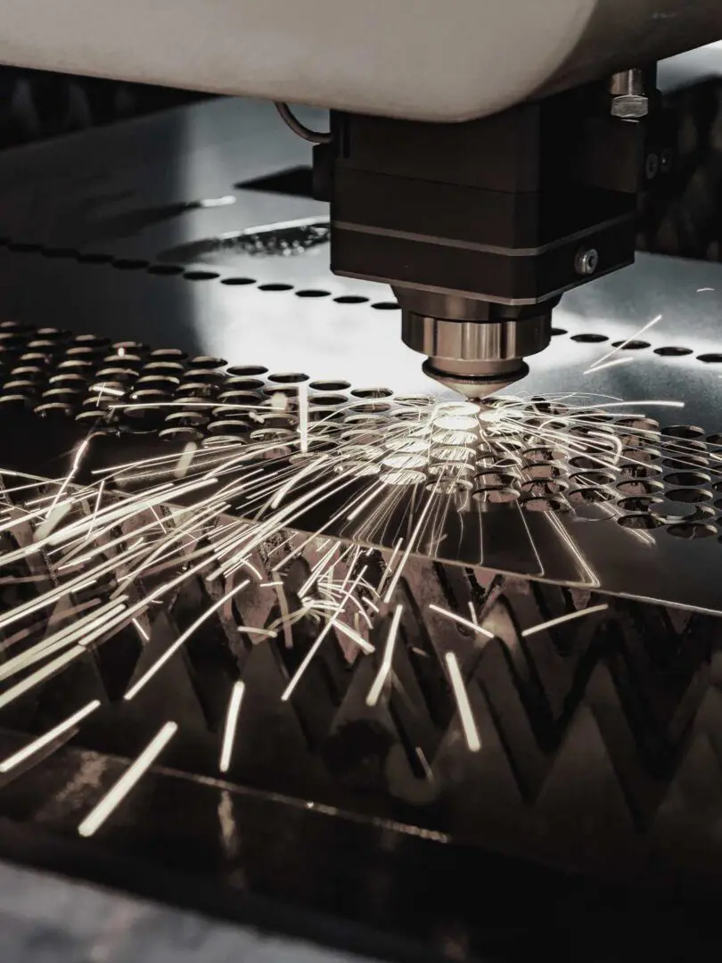 A machine cutting metal with sparks flying from it.