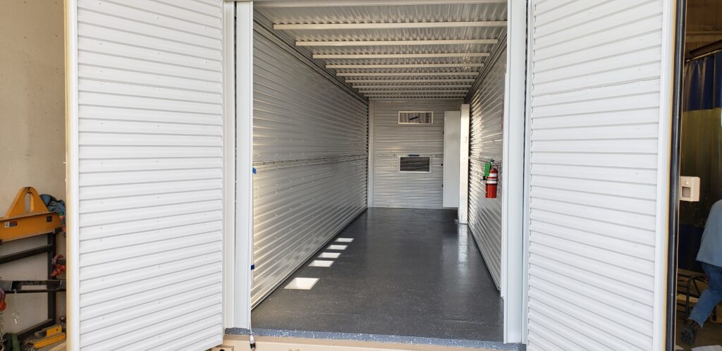 Shop-built shipping container fabricated for repeatable deployment across oil and gas projects