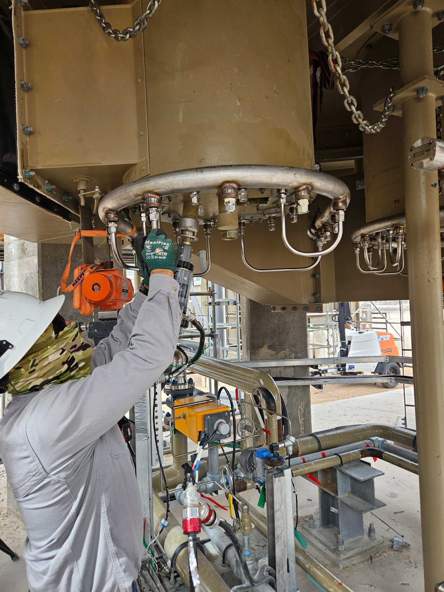 DSI electrical technician in PPE servicing field instrumentation at an oil and gas facility