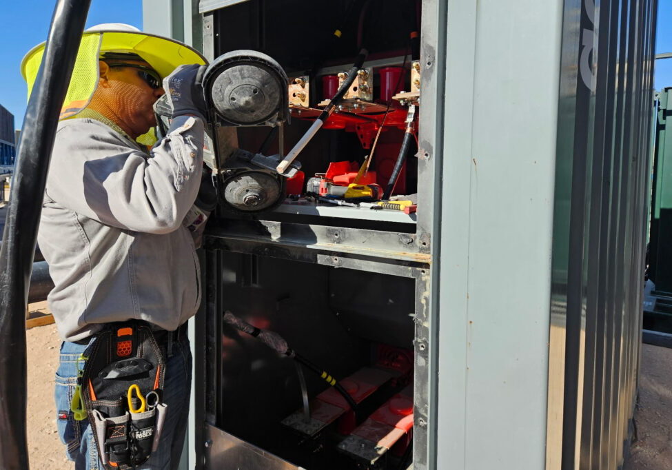 DSI field technician performing oilfield field services electrical integration on a pad site