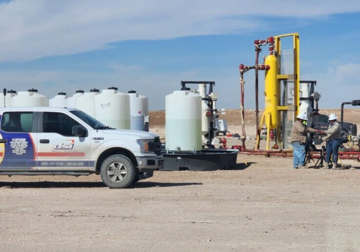Oil and gas field crews working around production equipment during a job site safety operation