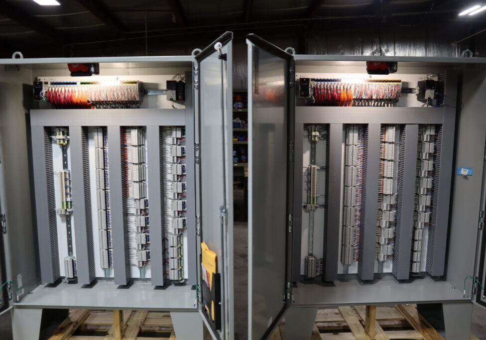Open industrial control panel showing PLC modules and terminal block wiring inside a DSI automation cabinet