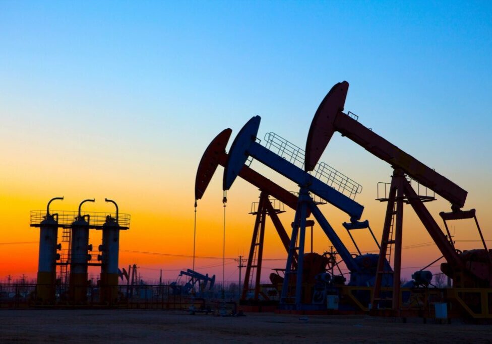 A group of oil pumps in the middle of an open field.